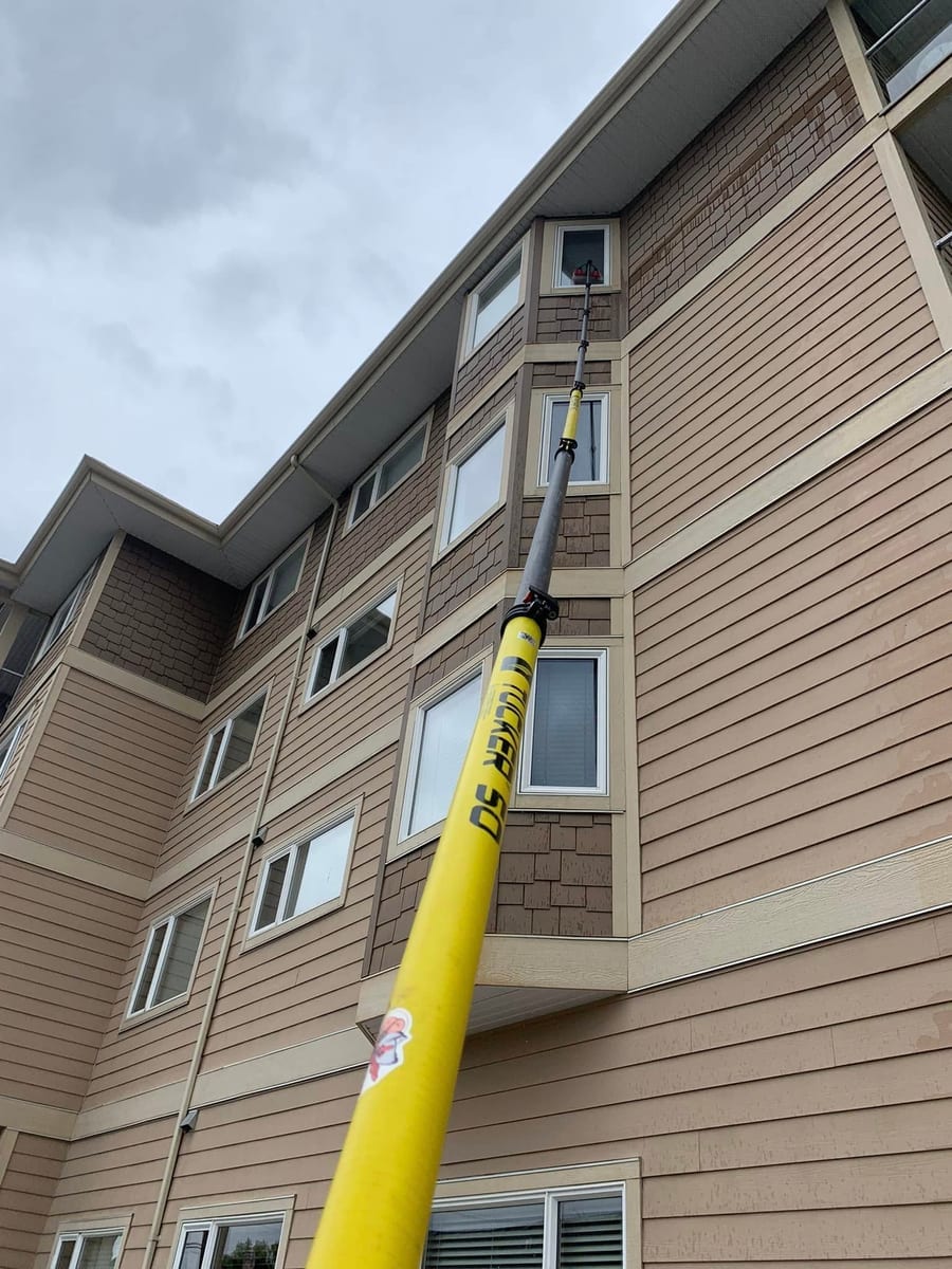 Water-fed pole window cleaning on multi-storey apartment building